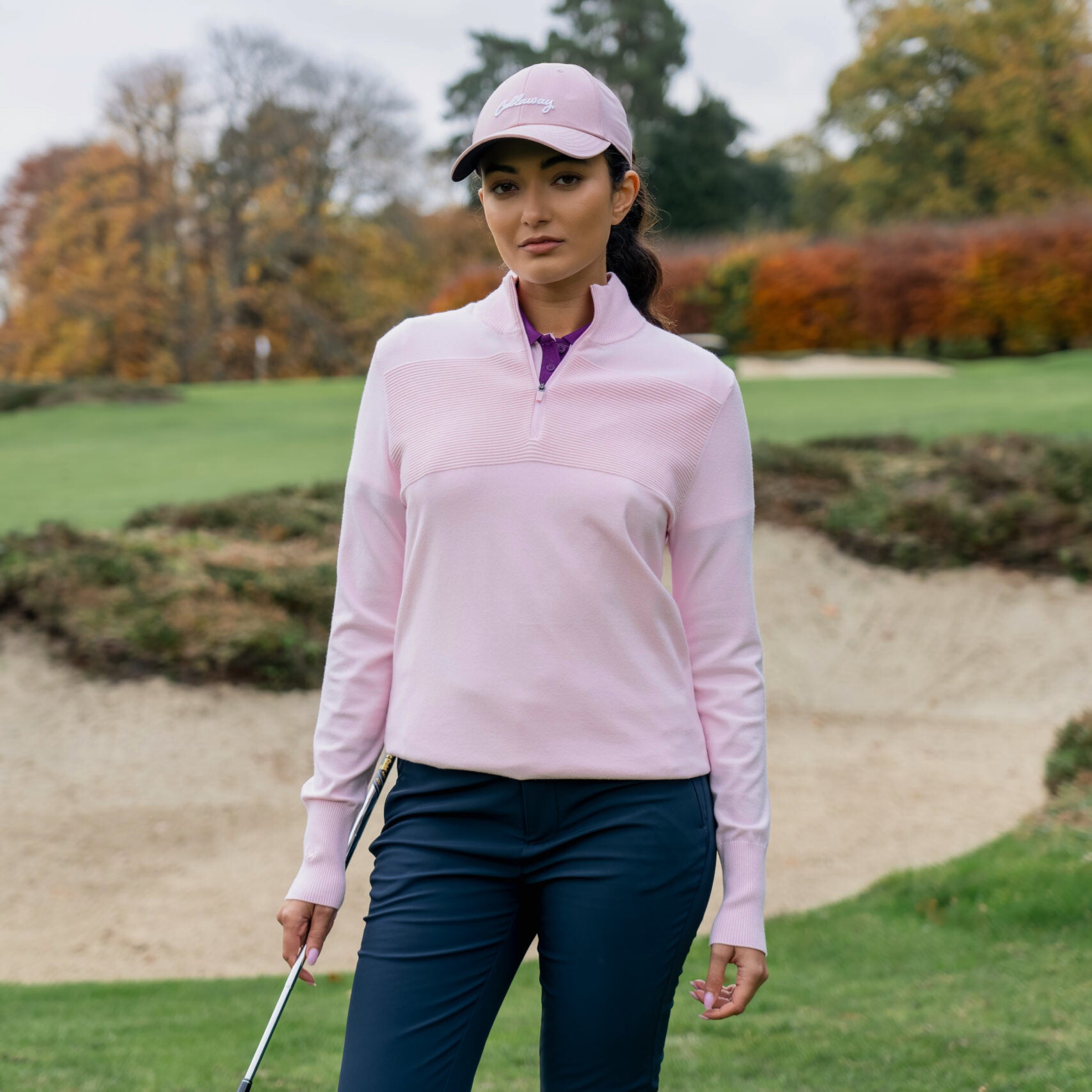 Golfista femenina vistiendo el jersey Callaway Soft Stretch Zip-Neck en Cherry Blossom en el campo de golf